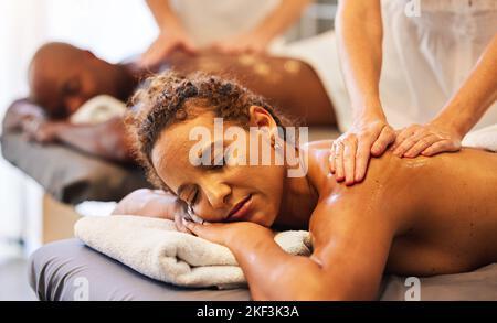 Black Couple Massage, Spa und entspannen Sie mit Öl im Urlaub, Urlaub oder Rückzug zusammen für die Bindung, Flitterwochen oder Ruhe. Schwarze Frau, Mann oder Paar Stockfoto