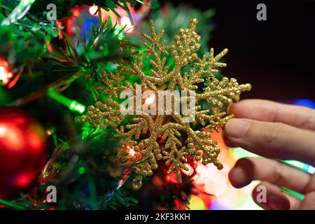 Weihnachtsbaum mit glitzernder Schneeflocke dekorieren Stockfoto