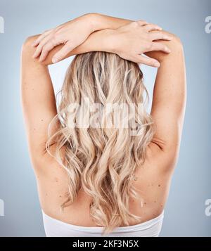 Blonde Haare, Frauen und Wellen, Haarpflege und Beauty-Salon Balayage, Haarfärbemittel und Farbkosmetik, Erweiterungen und Haarschnitt auf Studio-Hintergrund. Zurück Stockfoto