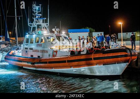 Roccella Jonica, Italien. 16.. November 2022. Ein Patrouillenboot mit Migranten ist auf dem Dock zu sehen. 28 Migranten, hauptsächlich aus Bangladesch, wurden auf einem Schiff in Not fast 115 Seemeilen vor der Küste gerettet und von der italienischen Küstenwache in die südliche Stadt Roccella Jonica (Italien) gebracht. Mitglieder des Roten Kreuzes und Ärzte ohne Grenzen leistten Migranten nach ihrer langen Reise aus Libyen lokale Hilfe. Kredit: SOPA Images Limited/Alamy Live Nachrichten Stockfoto