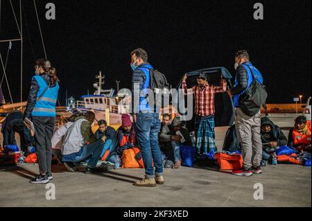 Roccella Jonica, Italien. 16.. November 2022. Mitglieder internationaler Organisationen werden bei ihrer Ankunft in Roccella Jonica mit Migranten gesehen. 28 Migranten, hauptsächlich aus Bangladesch, wurden auf einem Schiff in Not fast 115 Seemeilen vor der Küste gerettet und von der italienischen Küstenwache in die südliche Stadt Roccella Jonica (Italien) gebracht. Mitglieder des Roten Kreuzes und Ärzte ohne Grenzen leistten Migranten nach ihrer langen Reise aus Libyen lokale Hilfe. Kredit: SOPA Images Limited/Alamy Live Nachrichten Stockfoto