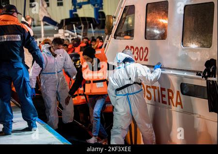 Roccella Jonica, Italien. 16.. November 2022. Bei der Ankunft in Roccella Jonica wird ein Migrant beim Aussteigen aus dem Patrouillenboot gesehen. 28 Migranten, hauptsächlich aus Bangladesch, wurden auf einem Schiff in Not fast 115 Seemeilen vor der Küste gerettet und von der italienischen Küstenwache in die südliche Stadt Roccella Jonica (Italien) gebracht. Mitglieder des Roten Kreuzes und Ärzte ohne Grenzen leistten Migranten nach ihrer langen Reise aus Libyen lokale Hilfe. Kredit: SOPA Images Limited/Alamy Live Nachrichten Stockfoto