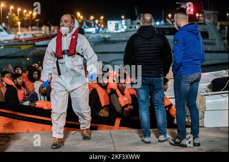 Roccella Jonica, Italien. 16.. November 2022. Migranten werden während der Landeoperation mit Schwimmwesten an Bord gesehen. 28 Migranten, hauptsächlich aus Bangladesch, wurden auf einem Schiff in Not fast 115 Seemeilen vor der Küste gerettet und von der italienischen Küstenwache in die südliche Stadt Roccella Jonica (Italien) gebracht. Mitglieder des Roten Kreuzes und Ärzte ohne Grenzen leistten Migranten nach ihrer langen Reise aus Libyen lokale Hilfe. (Foto von Valeria Ferraro/SOPA Images/Sipa USA) Quelle: SIPA USA/Alamy Live News Stockfoto