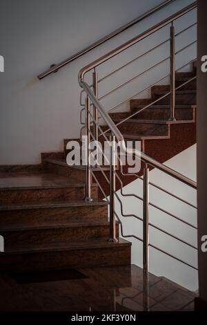 Eine vertikale Aufnahme von Treppen in einem Haus mit Metallgeländern Stockfoto