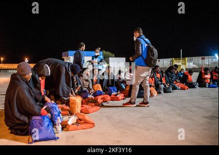 Roccella Jonica, Italien. 16.. November 2022. Ein Mitglied des UNHCR spricht mit Migranten bei ihrer Ankunft in Roccella Jonica. 28 Migranten, hauptsächlich aus Bangladesch, wurden auf einem Schiff in Not fast 115 Seemeilen vor der Küste gerettet und von der italienischen Küstenwache in die südliche Stadt Roccella Jonica (Italien) gebracht. Mitglieder des Roten Kreuzes und Ärzte ohne Grenzen leistten Migranten nach ihrer langen Reise aus Libyen lokale Hilfe. (Foto von Valeria Ferraro/SOPA Images/Sipa USA) Quelle: SIPA USA/Alamy Live News Stockfoto