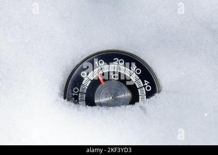 Thermometer mit celsius-Skala in einem Neuschnee platziert, der Temperaturen unter Null minus 13 Grad anzeigt - kaltes Winterwetter-Konzept Stockfoto