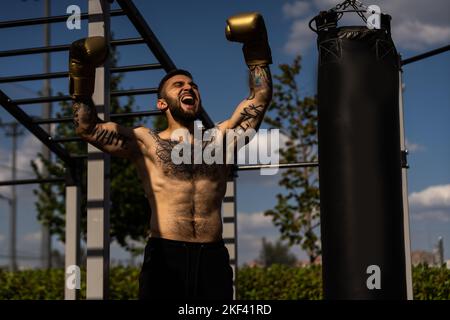 Mann in Boxhandschuhen übt im Freien Stockfoto