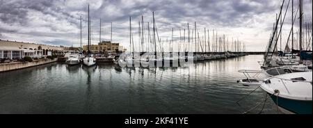 Panoramablick auf den Yachthafen mit vielen Segelbooten und Vergnügungsbooten legen an einem Schlechtwettertag mit dramatischem Himmel im sicheren Hafenbecken an. Stockfoto