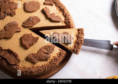 Kuchen mit Schnittstück und Klinge auf grauem Hintergrund, Nahaufnahme Stockfoto