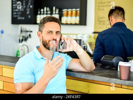 Treffen wir uns im Café. Mann mobile Gespräch Café Barista Hintergrund. Trinken Sie Kaffee, während Sie warten. Kaffee zum Mitnehmen für vielbeschäftigte Menschen. Mann mit Stockfoto