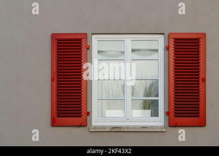 Italienische Fenster auf der grauen Wand Fassade mit offenen roten Farbe klassische Fensterläden. Fensterläden Wand europa Stockfoto