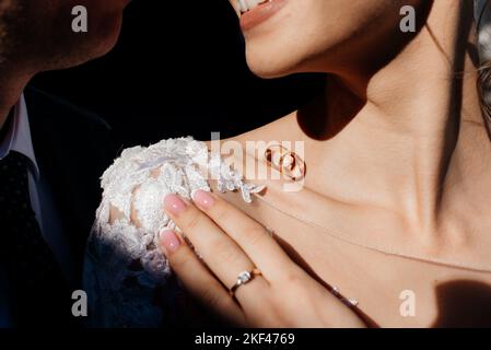 Hochzeitskonzept. Eheringe auf dem Schlüsselbein der Braut Stockfoto