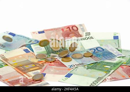 Euro Münzen fallen auf Euro Banknoten, Geldregen , hohe Kosten, Symbolbild Stockfoto