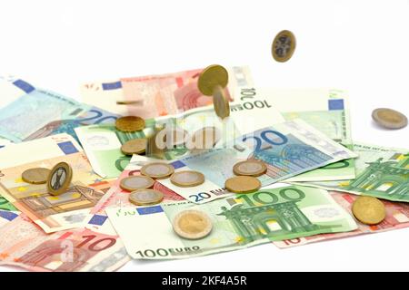 Euro Münzen fallen auf Euro Banknoten, Geldregen , hohe Kosten, Symbolbild Stockfoto