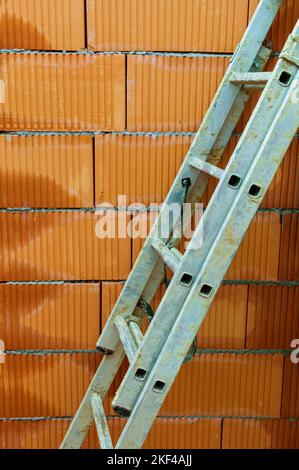 Ein Maurer beim Mauern eines Rohbaues in Massivbauweise. Ziegelmauer eines Einfamilienhauses Stockfoto