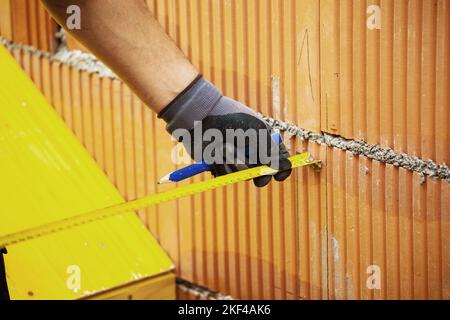 Ein Maurer beim Mauern eines Rohbaues in Massivbauweise. Ziegelmauer eines Einfamilienhauses Stockfoto