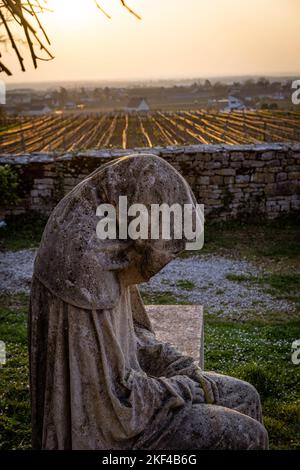 Eine vertikale Aufnahme einer mit Kapuze bemalten Steinstatue im Chateau de Gevrey Chambertin, in Burgund, Frankreich Stockfoto