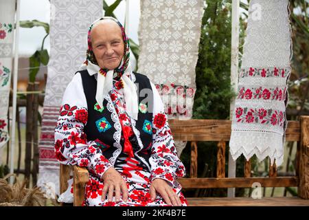 Eine alte weißrussische oder ukrainische Frau in einem bestickten Hemd. Slawische ältere Frau in ethnischer Kleidung. Stockfoto