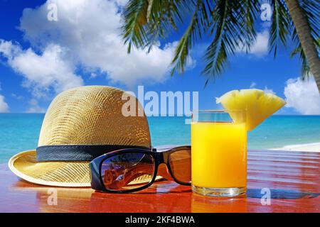 Sonnenhut mit Sonnenbrille und Fruchtsaft unter Palmen am Strand in Thailand, Stilllife, Urlaubsfeeling, Stockfoto