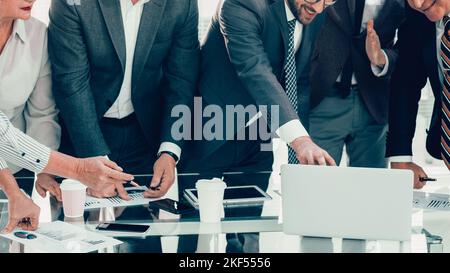 Gruppe von Mitarbeitern, die begeistert auf den Laptop-Bildschirm schauen Stockfoto