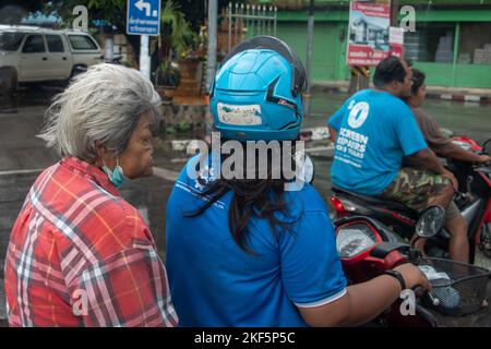 Ratchaburi, Thailand, 14 2022. NOVEMBER, Motorradfahrer warten an der Kreuzung einer Provinzstadt Stockfoto