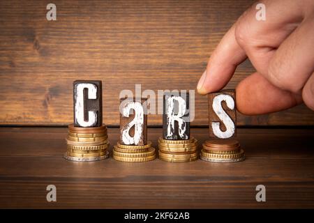 Autos. Holz Alphabet Blöcke und ändern. Kosten und Gewinn. Stockfoto