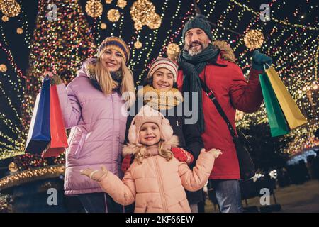 Foto von lustigen Schulkinder Ehemann Frau umarmt Kauf x-Mas präsentiert im Freien städtischen Stadtmarkt Stockfoto