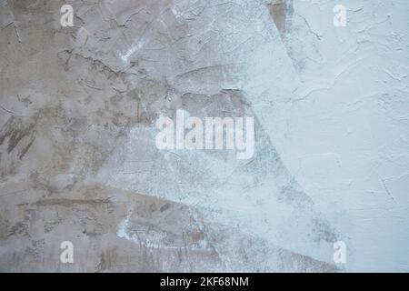 Eine Nahaufnahme einer alten verwitterten Wand mit einer Schicht weißer Farbe Stockfoto