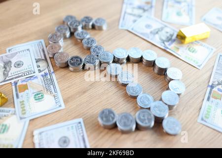 Goldbarren, Dollar-Banknoten und Dollar-Zeichen geformten Stapel von Münzen auf dem Tisch. Stockfoto