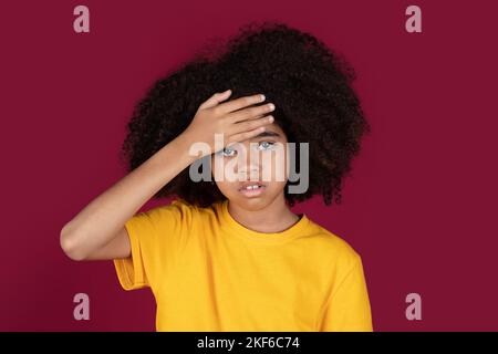 Peinliches afroamerikanisches Mädchen, das die Hand auf die Stirn hält Stockfoto