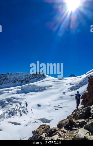 Beschreibung: Der Bergsteiger genießt die herrliche Aussicht auf den Jungfrau-Höhenweg. Jungfrau-Höhenweg, Berner Alpen, Schweiz, Europa. Stockfoto