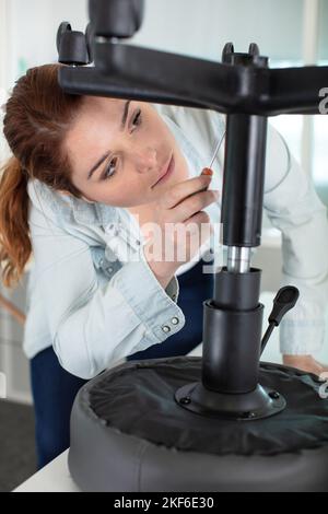 Eine Frau, die einen Bürostuhl zusammengebaut hat Stockfoto