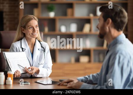 Ärztin Zeigt Medizinischen Test Ergebnisse An Männliche Patienten In Der Klinik Büro Stockfoto