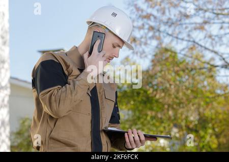 Der Baumeister benutzt sein Telefon Stockfoto