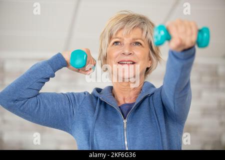 Ältere Fitness-Frau trainiert mit Kurzhanteln Stockfoto
