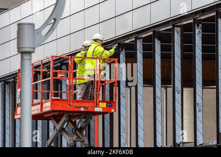 Arbeiter auf einem Kirschpflücker, der ein Gebäude in Coventry, West Midlands, Großbritannien, baut. Stockfoto