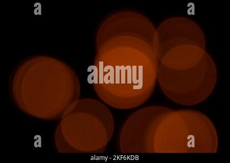 Orangefarbenes Bokeh leuchtet auf schwarzem Hintergrund Stockfoto