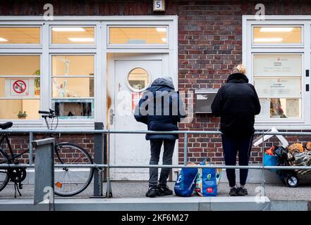 Hamburg, Deutschland. 16.. November 2022. Zwei Männer stehen vor dem Tagesreff caricare im Stadtzentrum. Die Hamburger Caritas hat eine neue Einrichtung eröffnet, die ein breites Spektrum an Dienstleistungen für Obdachlose bietet. Quelle: Daniel Bockwoldt/dpa/Alamy Live News Stockfoto