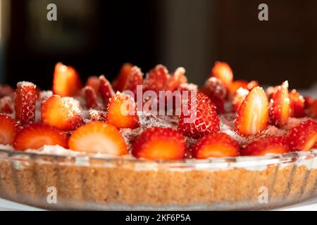 Erdbeerkuchen, Kokosnuss, Seitenansicht, Makrofoto in einer runden Platte bei Tageslicht. Geringe Schärfentiefe mit ausgewähltem Fokus. Stockfoto