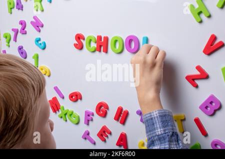 Wortschule aus bunten Buchstaben. Junge, der Worte macht Stockfoto