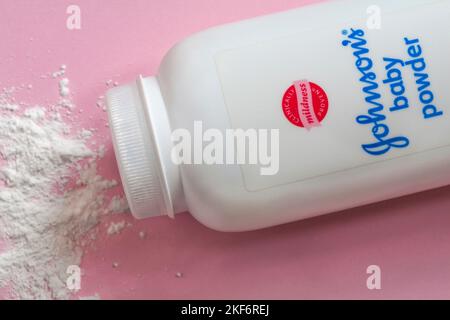 Johnsons Baby Powder Johnson und Johnson Baby Powder mit verschütteten Inhalten auf rosa Hintergrund - Talkum, Talkum Pulver Stockfoto