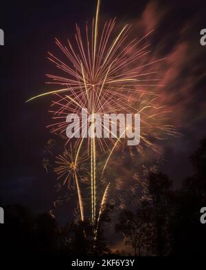 Bei einer Feier am 4.. Juli explodieren mehrere Feuerwerke am Nachthimmel. Stockfoto