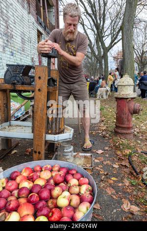 Detroit, Michigan - Jack VanDyke macht Apfelwein mit einer Apfelpresse auf einem Herbstfestival auf der nahen Ostseite von Detroit. Stockfoto