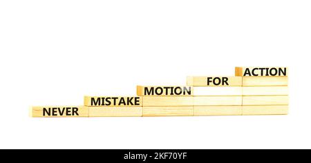 Fehler- oder Aktionssymbol. Konzeptwörter verwechseln niemals Bewegung mit Aktion auf Holzblöcken. Schöne weiße Tabelle weißen Hintergrund. Geschäftsfehler oder Stockfoto