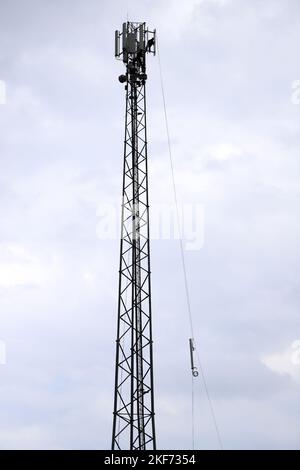 Mobilfunkturm, Mobilfunkstandort, Mobilfunkturm, Mobilfunkbasisstation, Mobilfunkturm. Installation eines Handy-Relais am Turm. Stockfoto