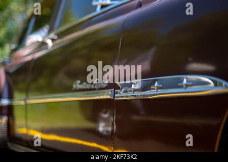 NISSWAS, MN – 30. JULI 2022: Verschwommene Ansicht der Seite eines Pontiac-Oldtimers aus dem Jahr 1950s auf einem Parkplatz auf einer Outdoor-Automshow. Stockfoto