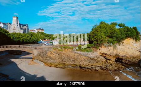 Blick auf den Rocher du Basta in Biarritz, Frankreich, mit dem Port des Pecheurs, dem Fischerhafen und der Sainte-Eugenie-Kirche im Hintergrund Stockfoto