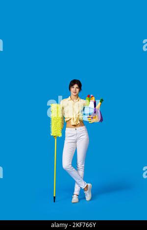 Frau in Gummihandschuhen mit Reinigungsmitteln Stockfoto