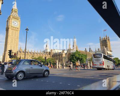 Ein Blick auf die Straße von London voller Verkehr und Menschen, mit Westminster Abby und Big Ben im Hintergrund, an einem sonnigen Tag im Sommer Stockfoto