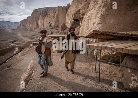 Bamyan, Afghanistan. 15.. November 2022. Zwei Taliban-Kämpfer patrouillieren an dem Ort, an dem in Bamyan eine monumentale, 38 Meter hohe Buddha-Statue in die Seite einer Klippe gehauen wurde. Zwei massive buddha-Statuen, die kleinere erreichen 38 und die größere erreichen 55 Meter, wurden um 600 n. Chr. erbaut und später von den Taliban mit Dynamit über mehrere Wochen zerstört, beginnend am 02. März 2001. Quelle: Oliver Weiken/dpa/Alamy Live News Stockfoto